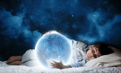 A small boy sleeping while holding a moon
