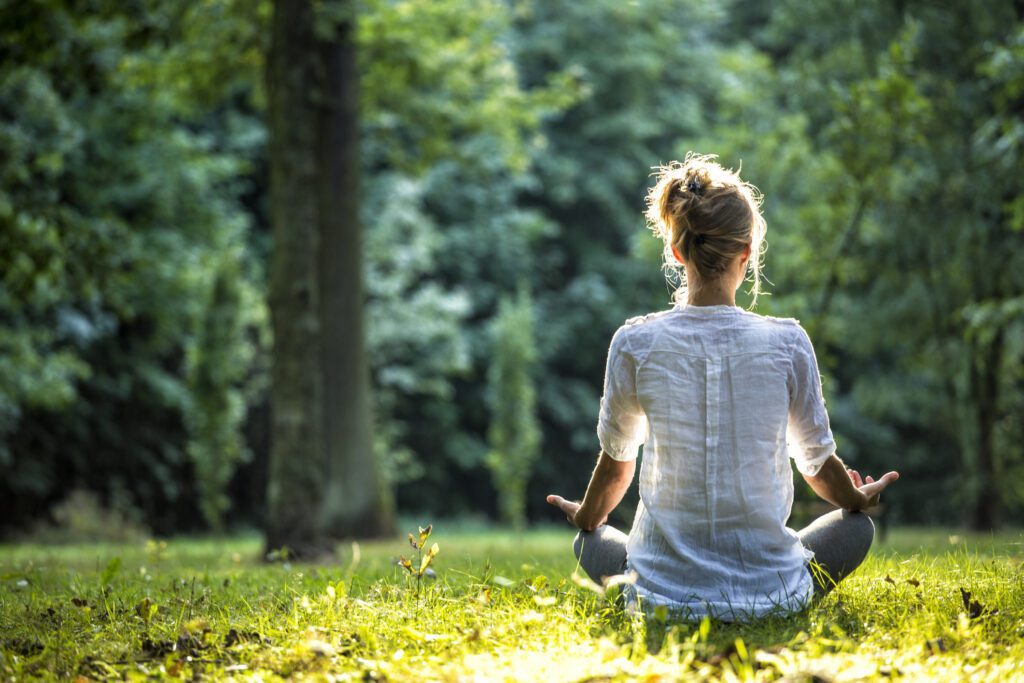 A girl doing meditation in an open field