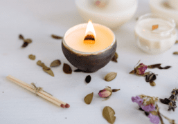 A candle along with some petals and a matchstick